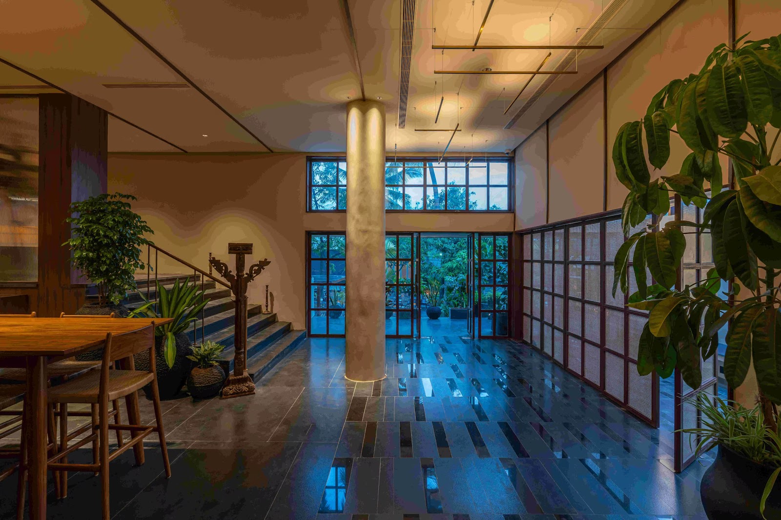 The covered upper room in glass and timber, plants along the window wall.