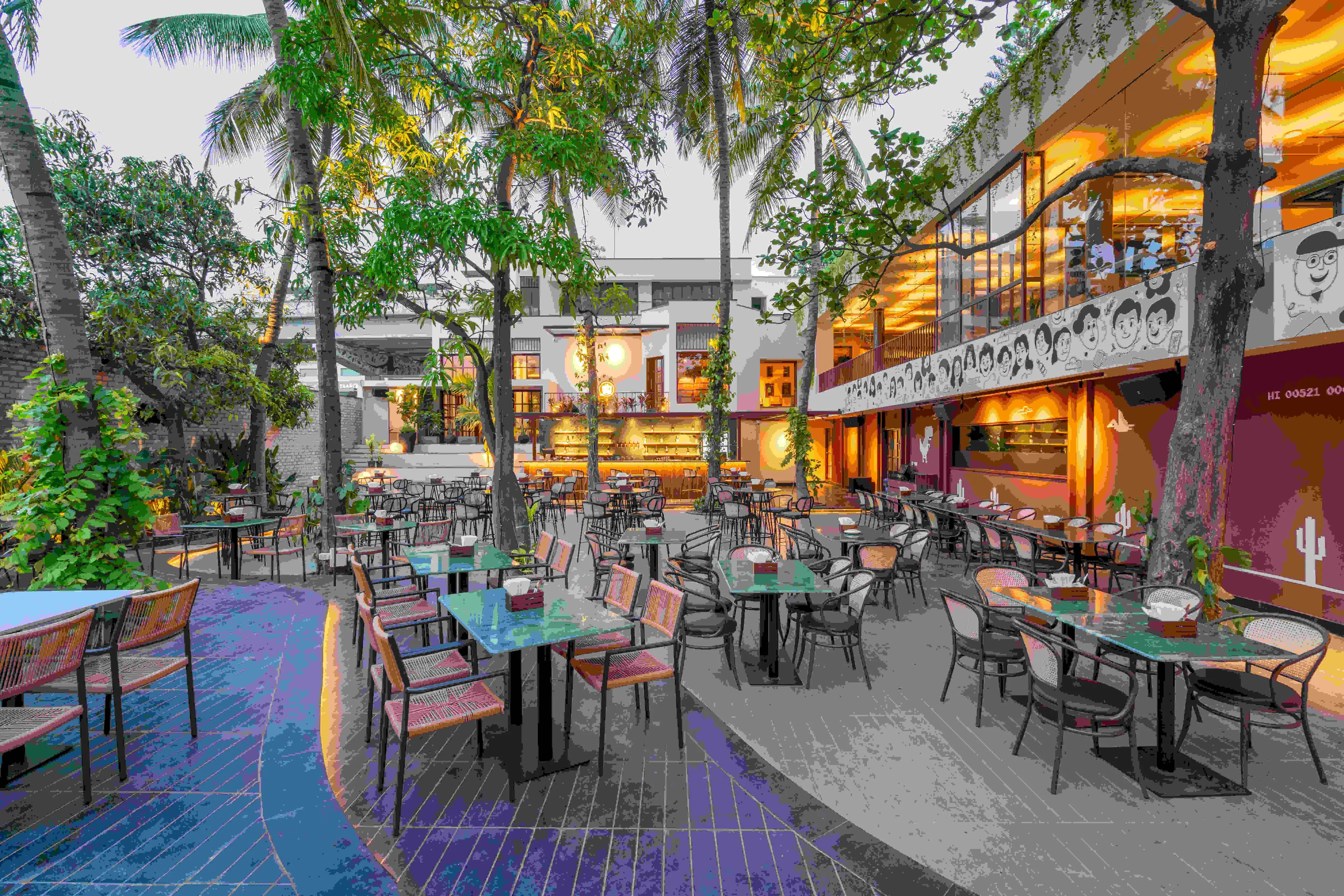 The yard at dusk from the upper level, tables running the length of it.